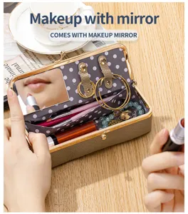 Detail of portable leather makeup box with built-in mirror and polka dot interior lining.