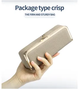 Detailed macro view of beige pebble grain leather eyeglass case with gold metal kiss-clasp