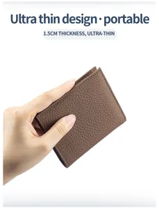 Close-up of ultra-thin brown leather bifold wallet being held in hand, 1.5cm thickness