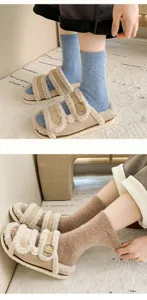 Detail of warm wool socks in blue and brown paired with fuzzy sandals on a white rug