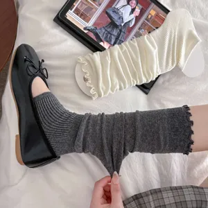 Close-up of elastic grey slouchy leg warmers with ruffle edges and knit texture