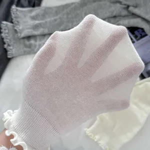 Close-up showing the breathable mesh texture of white thin ruffled stirrup leg warmers.