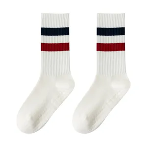 Calzini sportivi bianchi con strisce blu rosse e suola antiscivolo per yoga fitness.