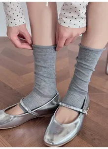 Detail shot of grey slouchy leg warmers paired with silver shoes, showcasing soft texture.