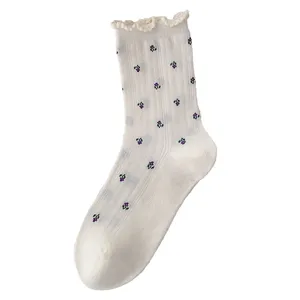 Elegant white crew socks for women featuring a delicate floral print and ruffled edges
