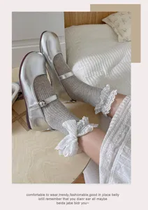 Detailaufnahme der silbernen Mary-Jane-Schuhe mit grauen Spitzen-Rüschensocken.