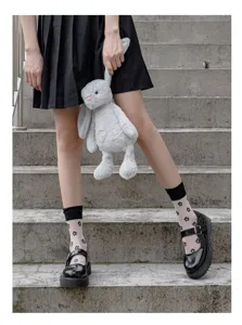 Calzini corti trasparenti da donna con motivi abbinati a scarpe eleganti e gonna.