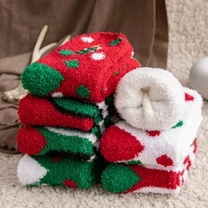 Macro detail of fuzzy Christmas socks showing soft coral fleece texture and festive patterns.