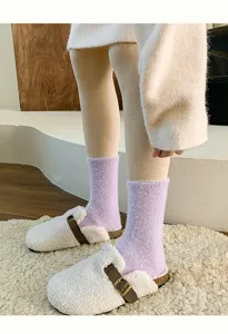 Detailansicht von lila flauschigen Mohair-Socken kombiniert mit weißen Fleece-Clogs.