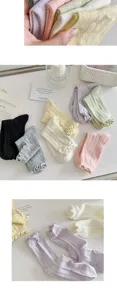 Detail shot of women's knit ruffle socks, soft pastel colors, comfortable breathable material.