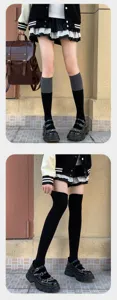 Detalle de calcetines bicolores gris-negro y medias negras por encima de la rodilla