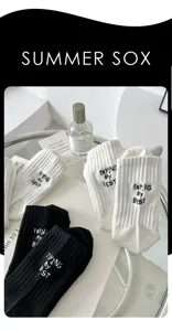 Detail view of stylish black and white cotton mid-calf socks featuring unique embroidery.