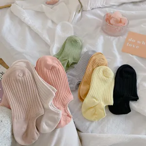 Detailed view of colorful ribbed low-cut socks in dopamine shades on a soft surface