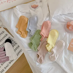Vibrant collection of colorful low-cut invisible boat socks displayed on white bedding.