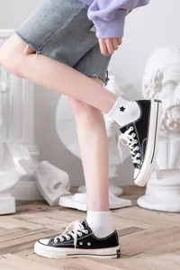 White cotton ankle socks with black star embroidery, paired with canvas shoes for women.