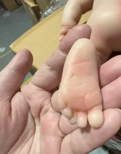 Close-up detail of a 12-inch full silicone reborn doll foot showing a minor flaw