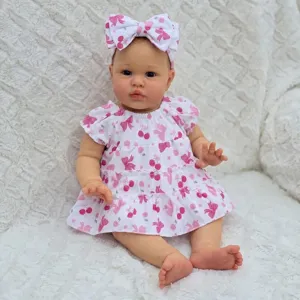 Detailed view of a 22-inch reborn doll wearing a cherry and butterfly print dress