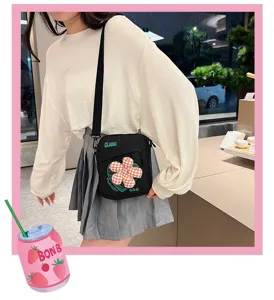 Detalle de un bolso bandolera negro con un parche de flor usado por una modelo