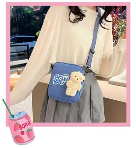 Primer plano de bolso bandolera de nailon azul con osito de peluche y estampado Stayin
