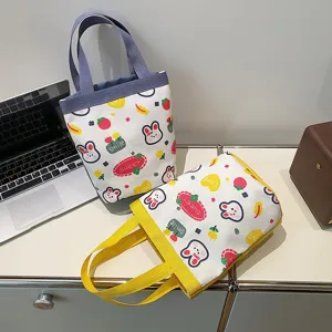 Detailed view of cute cartoon canvas handbags featuring rabbit and strawberry patterns.