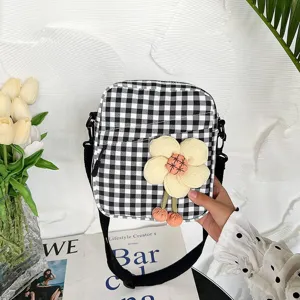 Primer plano de un mini bolso bandolera de cuadros con flor de tela 3D decorativa