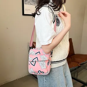 Vista detallada del bolso bandolera de nailon rosa con estampado de oso en modelo