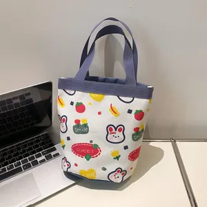 Detailed view of cute cartoon canvas tote bag with bunny pattern on desk next to laptop
