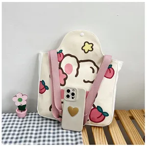 Canvas draagtas met cartoon konijn en een smartphone voor maatreferentie op een houten bank