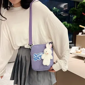Bolso bandolera morado moderno con un lindo colgante de conejo de peluche blanco y parche