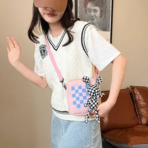 Detalle del bolso rosa dulce con cuadros azules y muñeco de conejo a cuadros