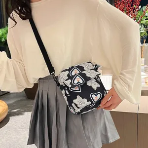 Bolso bandolera de nailon con estampados de osos y corazones en primer plano sobre modelo