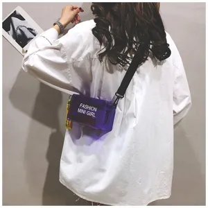 Detailweergave van een stijlvolle paarse transparante jelly mini crossbody tas gedragen door model.