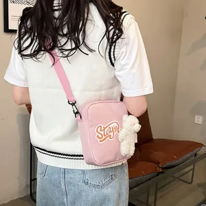 Bolso bandolera de nailon rosa con colgante de osito blanco y logotipo Stay In.