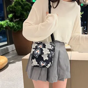 Detalle de bolso bandolera de nailon con estampado de oso llevado por una modelo
