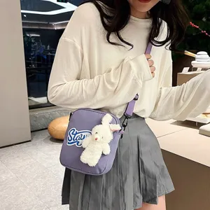Modelo con un lindo bolso bandolera morado con un conejo de peluche y bordado
