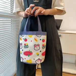 Close-up of a cute cartoon canvas lunch bag with rabbit and strawberry patterns.