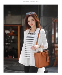 Asiatisches Model mit stilvoller brauner Umhängetasche mit Lychee-Muster und Quaste
