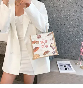 Detailansicht einer Leinenhandtasche mit süßem Brot-Doodle-Print und gewebten Tragegriffen
