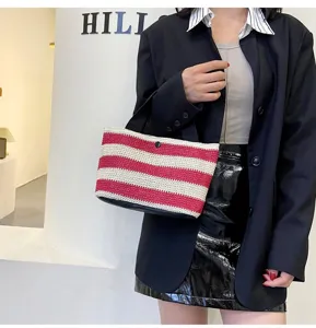 Femme moderne portant un sac à main en paille tressée à rayures rouges et blanches
