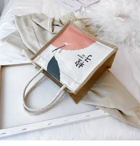 Nahaufnahme einer rustikalen Jutetasche mit dekorativem Orangen-Print und geflochtenen Griffen.