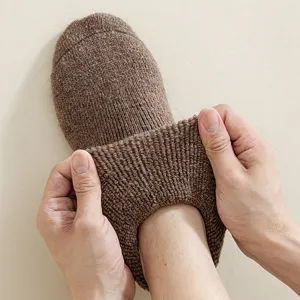 Men's thick wool winter socks in brown being stretched to show high elasticity