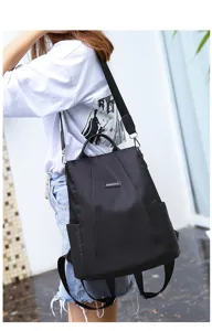 Detailed view of a stylish black anti-theft nylon backpack for women worn on shoulder