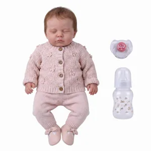 Detailansicht einer Reborn-Puppe mit rosa Strickjacke, Schnuller und Babyflasche