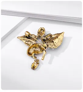 Detailed view of the back mechanism of a vintage gold magpie and strawberry brooch pin