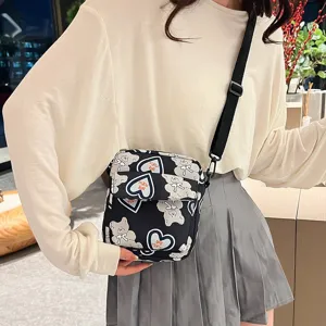 Vista detallada de un bolso bandolera de nailon con estampado de osos y corazones en modelo