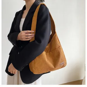 Detailed close-up of a large ginger corduroy shoulder bag showing side pocket texture