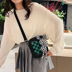 Chica con bolso bandolera japonés negro a cuadros con un lindo muñeco de conejo