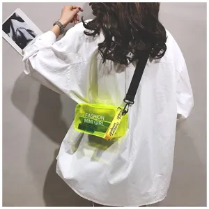 Detail van een neon gele transparante jelly crossbody tas gedragen op een wit shirt.