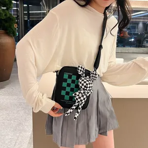Detalle del bolso bandolera a cuadros con muñeco de conejo usado por una modelo
