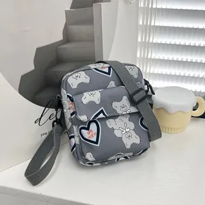 Detalle del bolso bandolera de nailon gris con estampado de osos y corazones lindos